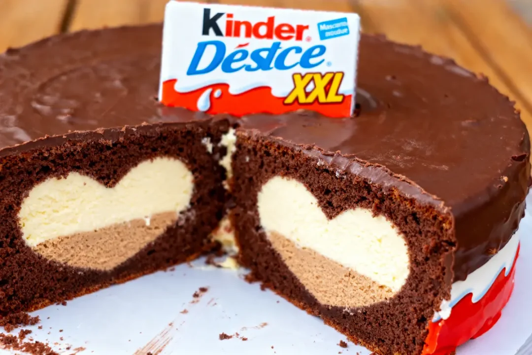 Gâteau au chocolat avec cœur vanille coupé, emballage Kinder Délice XXL sur le dessus.