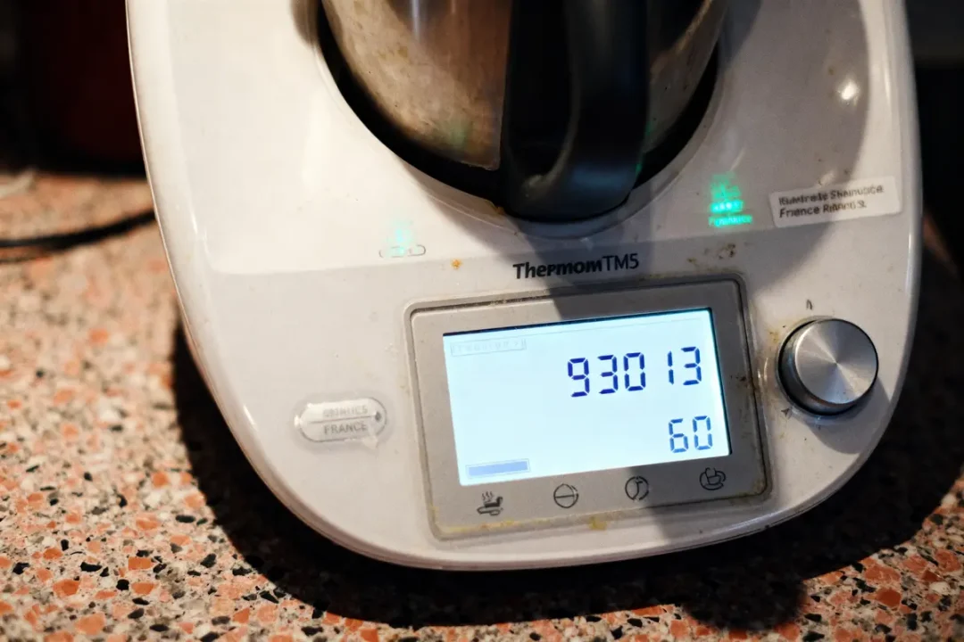 Thermomix TM5 affichant l'écran numérique avec les numéros 93013 et 60 sur un plan de travail.