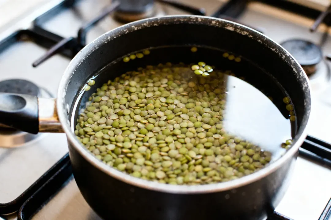 Lentilles vertes en cuisson dans une casserole sur gaz pour optimiser le temps de cuisson des lentilles