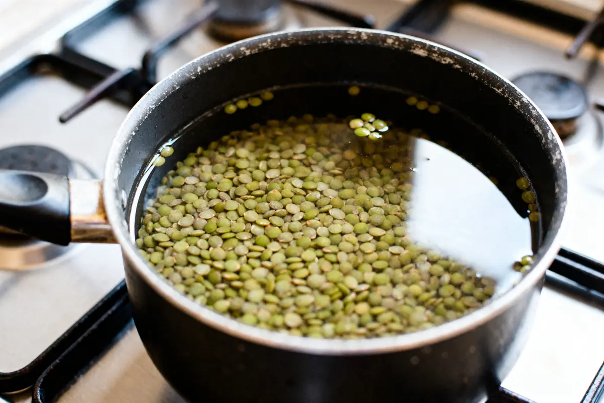 Lentilles vertes en cuisson dans une casserole sur gaz pour optimiser le temps de cuisson des lentilles