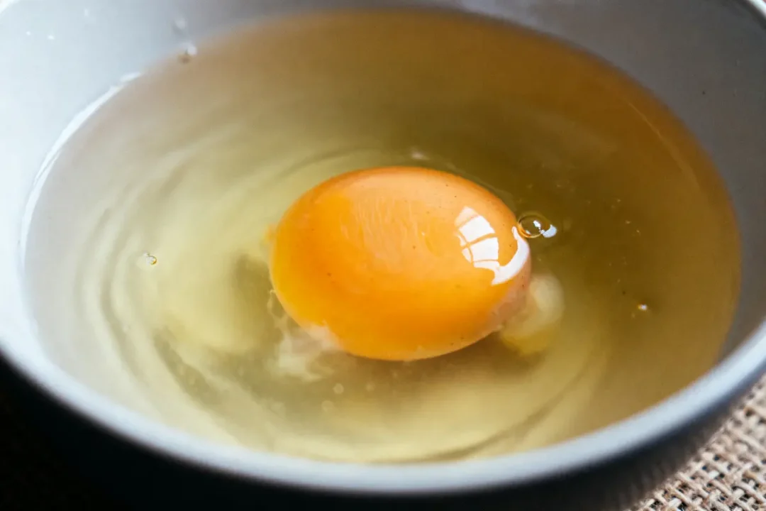 Oeuf flottant dans un bol pour test de l'oeuf dans l'eau fraîcheur