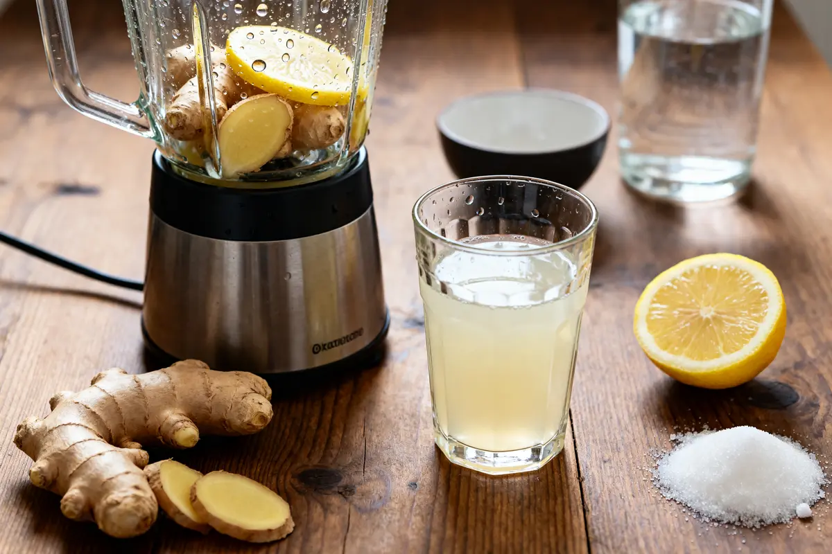 Blender avec gingembre et citron, verre de jus, recette de jus de gingembre maison.
