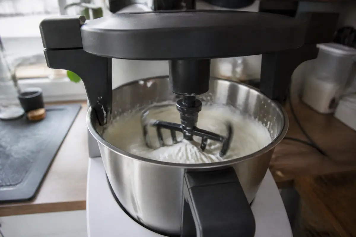 Batteur de cuisine Monsieur Cuisine utilisé pour mélanger une pâte dans le bol en inox
